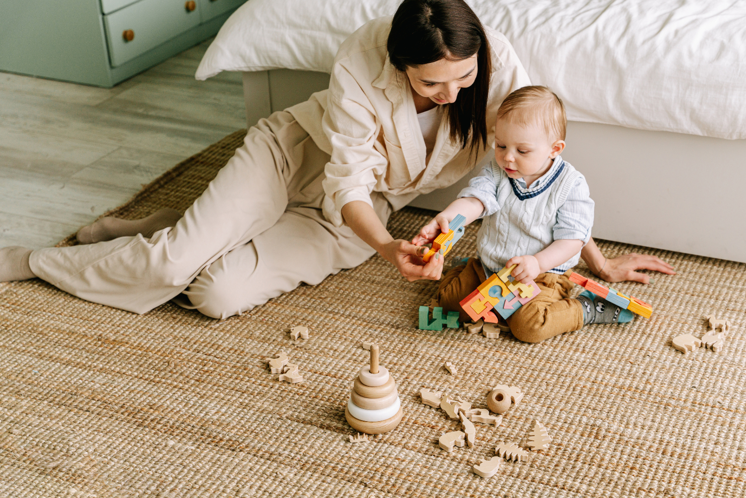 Parent watching baby playing with small toys