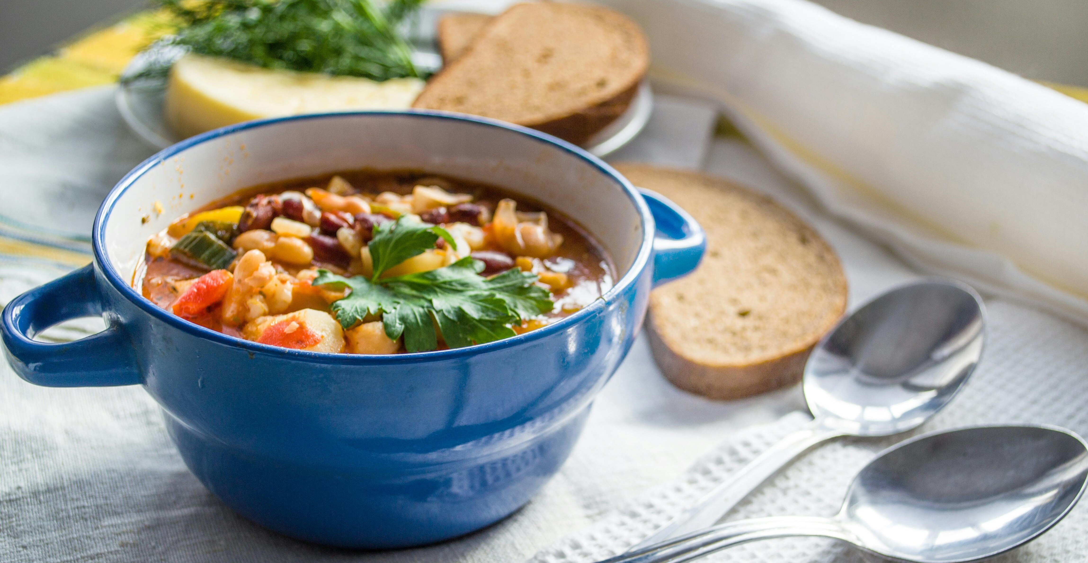 hearty soup, blue bowl, parsley garnish, cozy meal, bread, winter comfort, family gathering, shared warmth