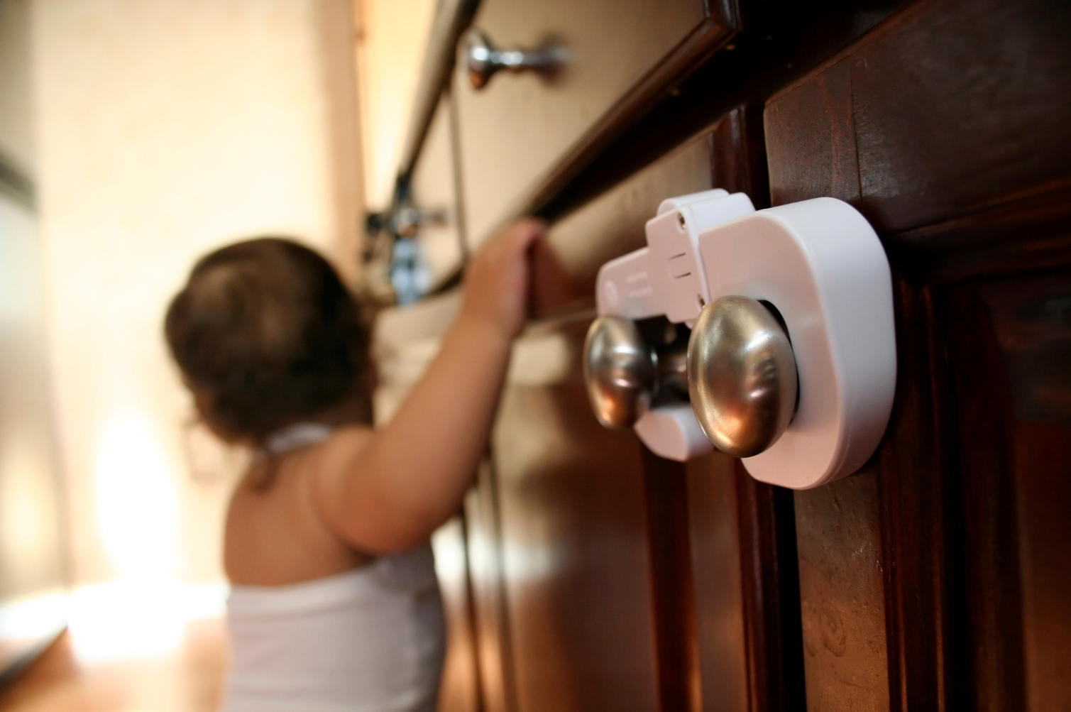 Child-proof latch securing a cabinet to prevent access