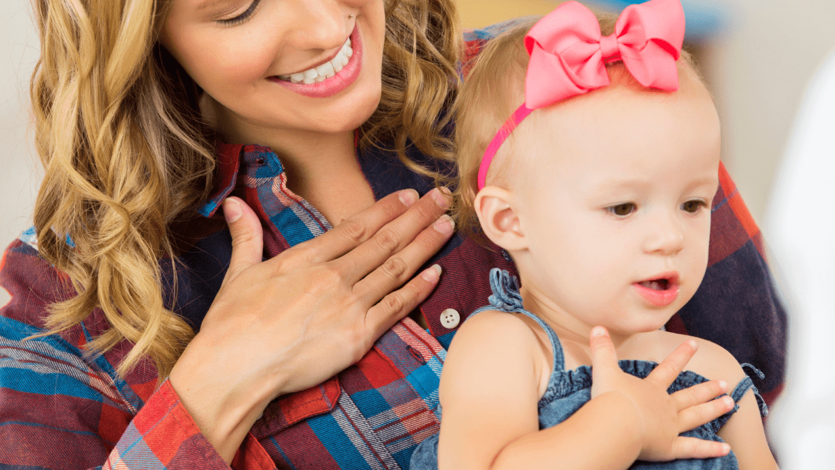 Parent teaching baby sign language.